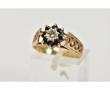 A 9CT GOLD SAPPHIRE AND DIAMOND CLUSTER RING, designed with a central illusion set, single cut diamond, within a surround of 