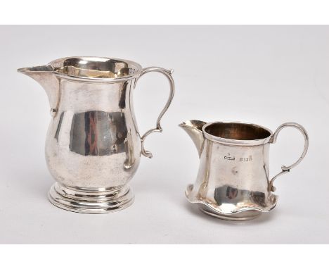 TWO EARLY 20TH CENTURY SMALL SILVER CREAM JUGS, the first of baluster shape with stepped circular base and scrolling handle, 