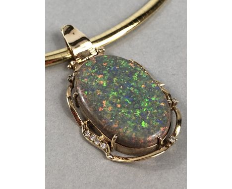 Single Collet pendant with a wavy frame edge of yell swags, set with an oval cabochon cut Opal and round Brilliant cut diamon