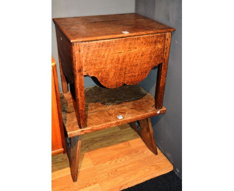 An antique oak occasional table, of low proportions, raised on splat supports, with carved club shaped motifs, 36cm high x 56