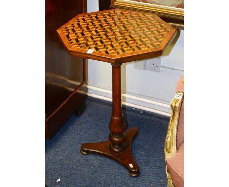 An early Victorian mahogany octagonal games table, with parquetry inlaid top raised on turned column support and platform bas