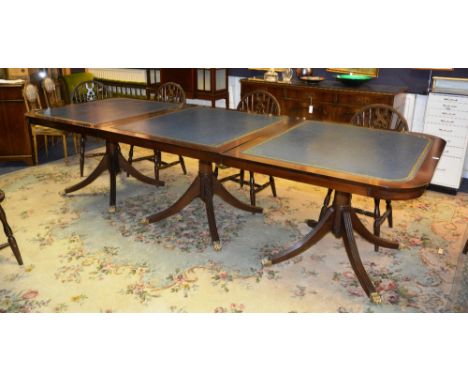 A Regency style mahogany triple pedestal dining /boardroom table, the rounded rectangular top fitted with tooled blue skiver,