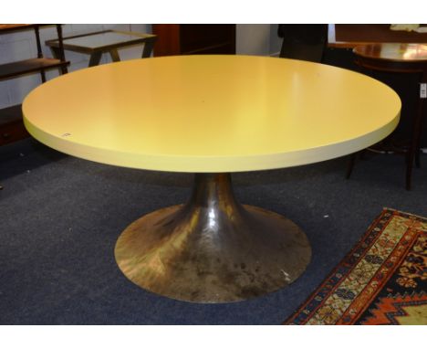 A contemporary kitchen table, the yellow circular top raised on flared beaten metal column, 148cm diameter x 75cm high