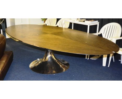 A contemporary dining table, the quarter venered oval top, raised on beaten metal column of glazed form, 153cm wide x 75cm hi