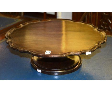 A mahogany fixed Lazy Susan, the scalloped circular top raised on waisted column and plinth base, 50cm diameter x 16cm high