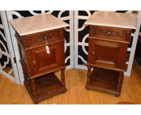 A pair of French marble topped side cabinets, each with moulded top over panelled frieze door, raised on baluster turned supp