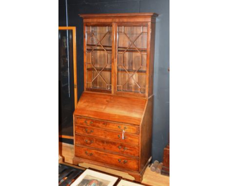 A George III mahogany bureau bookcase, the projected dentil cornice over astragal glazed doors, enclosing stretcher, the moul