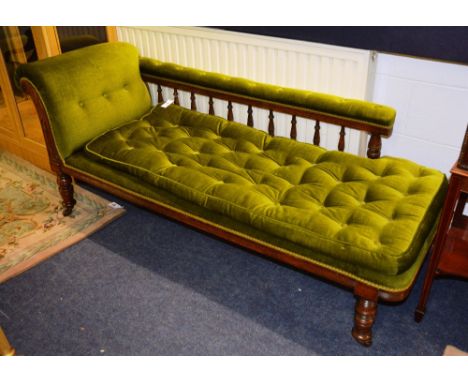 A Victorian chaise longue, the cushioned balustrade scrolling from left to right, with loose cushion button seat, raised on b