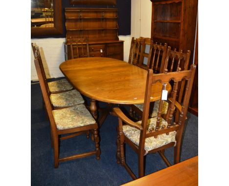 An Ercol type dining suit, comprising of drawer and plate rack, extending dining table and eight dining chairs (10)