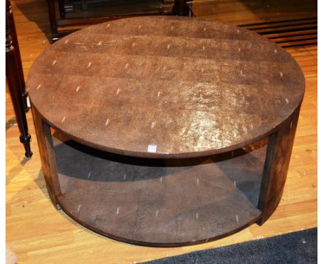 A contemporary coffee table, the whole covered in faux shagreen, with circular top, on supports, united by shelf, 100 cm diam