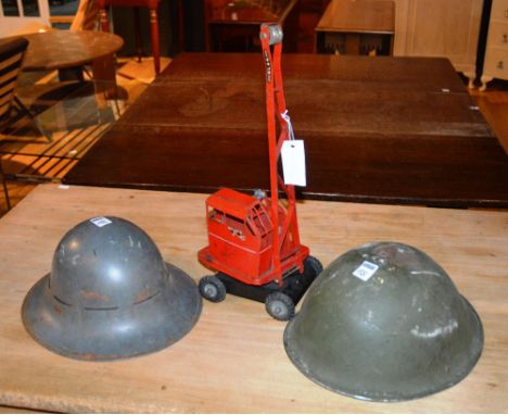 Vintage Jones KL44 child's crane painted in red, made by K&L steel founders, 45cm high, also two army helmets(3)