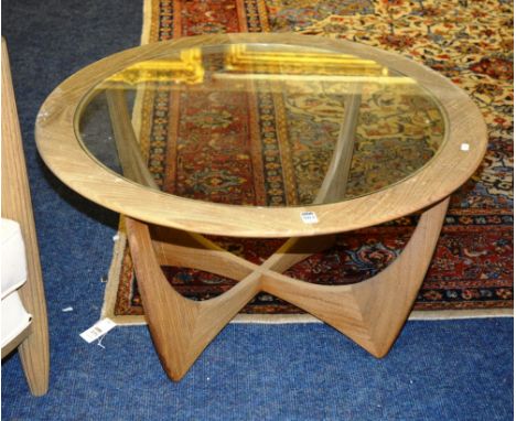 An Ercol coffee table, the circular glazed top raised on shaped x-frame legs, 83cm diameter x 46cm high