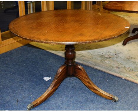 A mahogany snap top circular supper table, raised on turned column support and reeded tripod base, 75cm high x 105cm wide