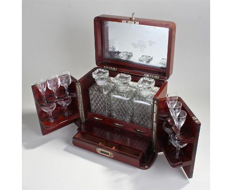 Early 20th Century mahogany cabinet decanter case. with mirror backed lid opened to three decanters, two doors holding ten gl