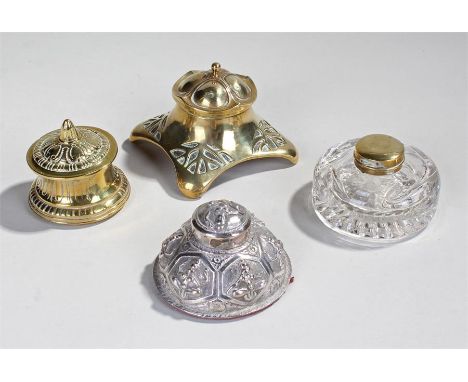 Indian white metal inkwell, of dome form with deity's, together with two brass examples and a glass and brass lidded example,