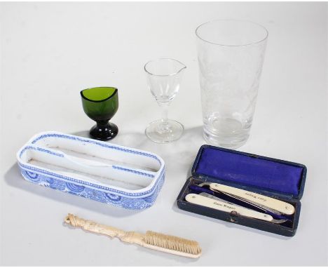 Oriental ivory toothbrush the handle carved as a lady, a ceramic toothbrush holder, two boxed corn razors, a green glass eye 