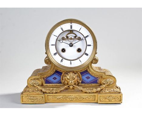 19th Century gilt brass French drum clock, the ribbed case above arched sides with porcelain plaques and lion mask decoration