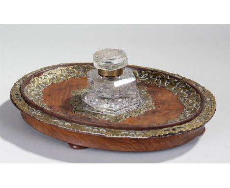 Victorian walnut and glass inkwell, the oval dished walnut base with applied brass foliate and scroll border, a glass inkwell