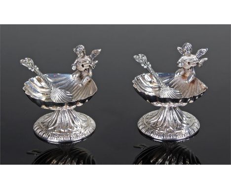 Pair of silver salts, surmounted by a cherub playing an instrument above a shell bowl and leaf base, together with a pair of 