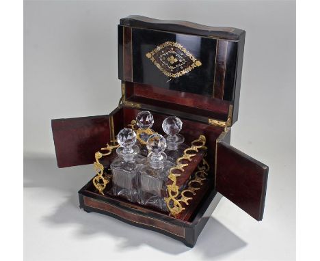 Victorian ebonized decanter box containing lift out tray with ornate gilded handle,gilded glass racks and four decanters. the