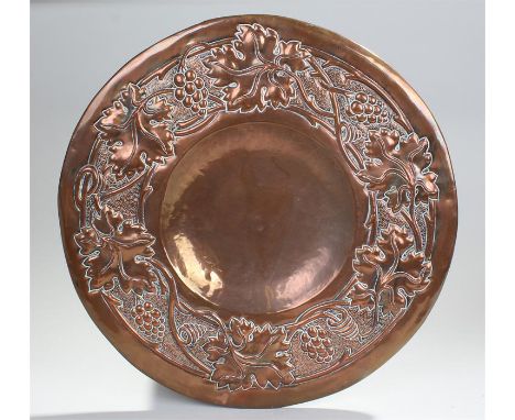Newlyn style copper charger, the dish centre with a fruit and leaf surround, 46cm wide