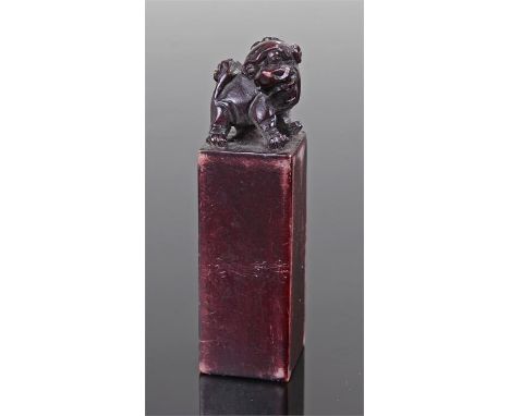 Chinese hardstone seal, surmounted by a dog of foo above a square section column, 7cm high