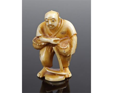 Meiji period Japanese ivory netsuke, carved as a standing figure holding a basket and a tool to his feet, signed to the base,
