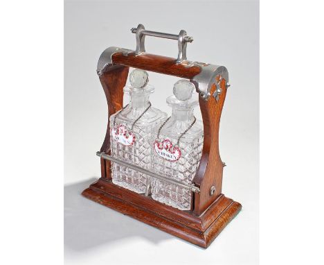 Edwardian oak Tantalus with chrome embellishments and handle, two decanters, two enamel wine labels whiskey and brandy. 27cm 