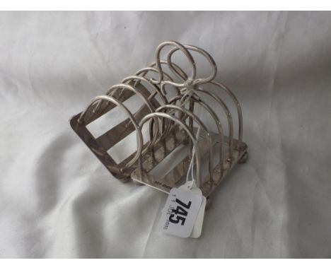 Pair of four division arch bar toast racks, raised on  ball feet, 3.25" long Shef 1904 by M &amp; W 210g.   