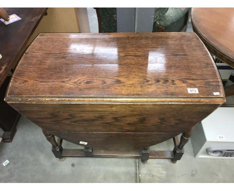 A 1930s oak gate leg table