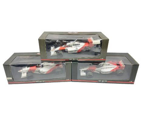 Three Paul's Model Art 1:18 scale die-cast McLaren racing cars - Mercedes MP4/11 D. Coulthard; MP4/4 A. Prost; and Mercedes M