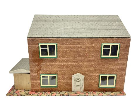 Scratch-built wooden doll's house of double fronted form with side garage, simulated brick walls under a faux tiled roof, the