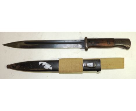 A WWII period bayonet with wood grip, straight deeply fullered blade and with metal scabbard  stamped "J Sch 1940" having ori