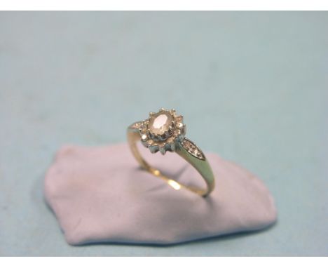 A 9ct. gold dress ring, clear stones and central pale stone, claw setting, size L/M