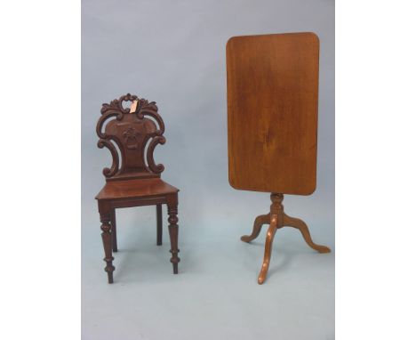 A Victorian mahogany hall chair, back carved with leaf and C-scrolls, and a Victorian mahogany tripod table, with rectangular