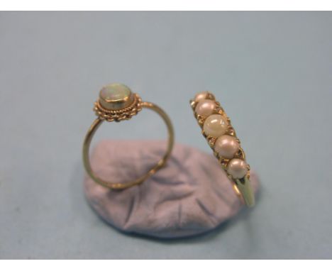 An 18ct. gold ring, set five pearl-type stones, in carved setting, and a 9ct. gold and opal ring