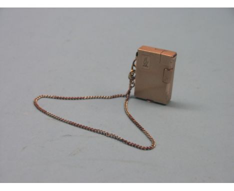 A yellow-coloured metal cigarette lighter, engine-turned, on 9ct. two-colour gold chain