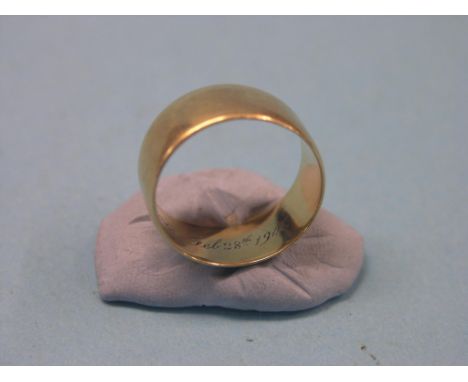 A gentleman's 18ct. gold band wedding ring, personalised, size T, 8.9 grams