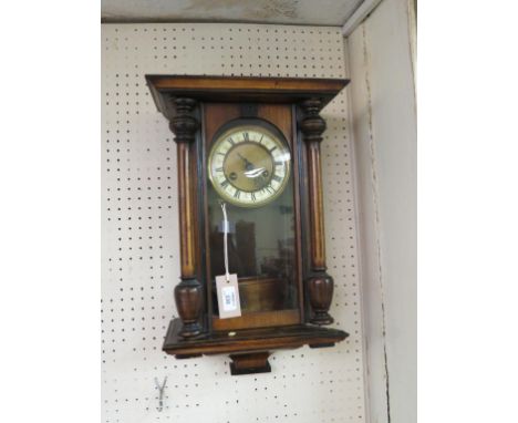 A 19th century German wall clock, with enamelled chapter ring and gong-striking movement, grid-iron pendulum, with key, walnu