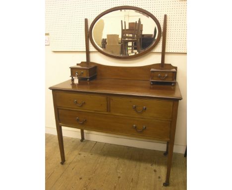 An Edwardian inlaid mahogany dressing table, oval bevelled mirror above two short drawers, one long and two short further dra
