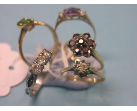 Four various 9ct. gold dress rings, and a silver ring set three clear stones 