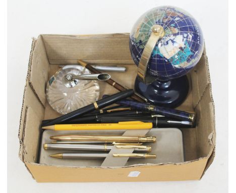 A desktop globe and various pens.  