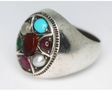 A contemporary multi gemstone ring set with a central amber cabochon and surround by moonstone, turquoise, garnet cabochons, 