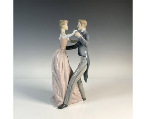 Glossy figurine capturing a loving scene of dancing couple. The woman is attired in an elegant pink dress adorned with sculpt