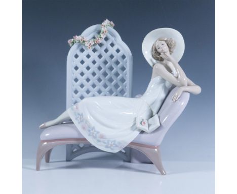 A glossy figure of a woman leisurely lying on her chaise lounge with a book and with a floral garland-adorned screen behind h