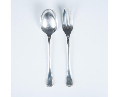 A set of sterling silver solid serving utensil; a three prong fork and spoon. Each handle is decorated in a palm and lotus le