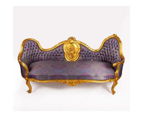 A beautiful French style sofa with lavender and magenta patterned cushion and sofa back. Accented with wooden carved gilded f