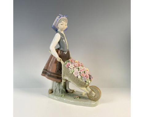 A glossy figure of a young woman pushing a wheelbarrow full of colorful delicate flowers. Lladro backstamp. This item has its