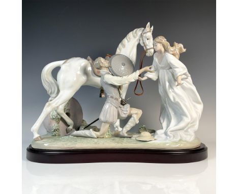 A glossy figure depicting a knight kneeling before a woman in a flowing white dress, her hair adorned with flowers, with the 