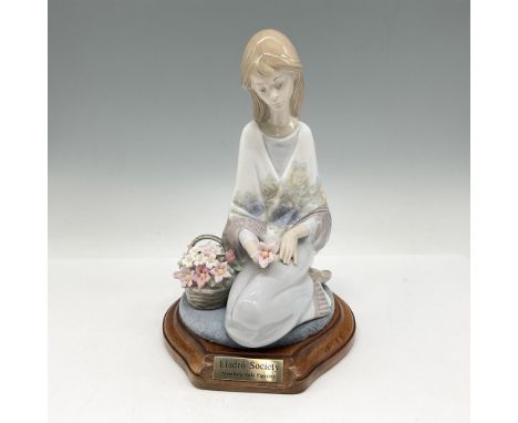 Glossy figure. Young woman seated next to a basket of flowers. Collectors Society Piece from 1988. Lladro backstamp. This ite